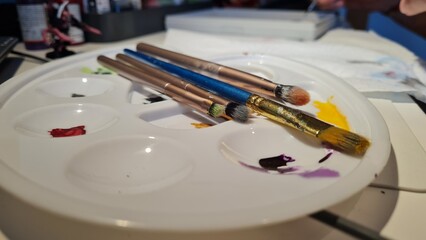 Fototapeta premium Creative Workspace: Inspiring View of Paintbrushes and a Paint Testing Board on a Table, Perfect for Artistic Exploration and Expression