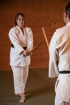 Woman poses ready to use sword in Aikido