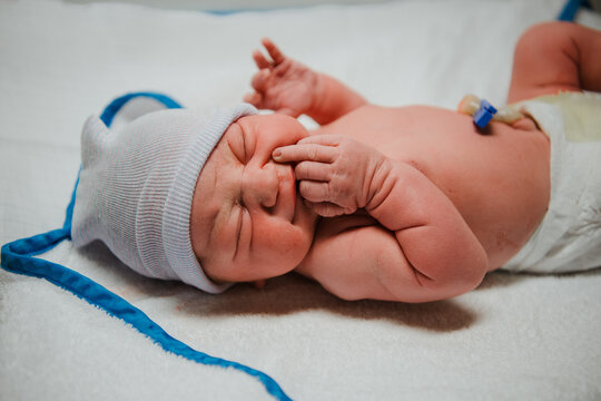 New Born Baby lying with hand on face