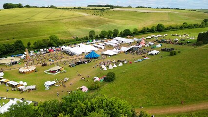 Aerial shot of the Chalke History Festival with tents and fairground rides in the Chalke valley
