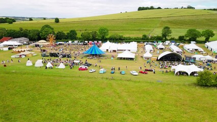 Aerial shot of the Chalke History Festival with tents and fairground rides in the Chalke valley