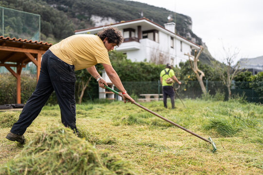 Male worker cleaning garden.