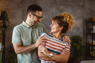 Naklejka premium Portrait of adult couple wife and husband hug and stand at home