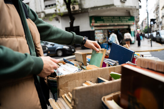 unrecognizable man selecting used books at a flea market