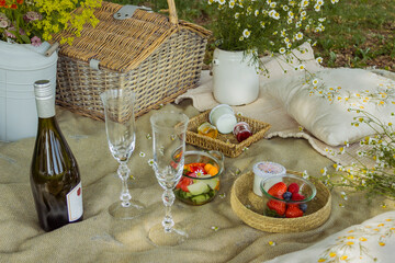 Beautiful white boho style decor. Picnic in nature on the grass under the tree