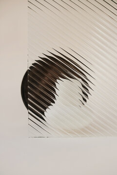 Glass with diagonal stripes pattern distorting silhouettes