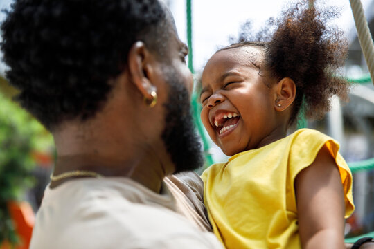 Cheerful daughter and father enjoying in park