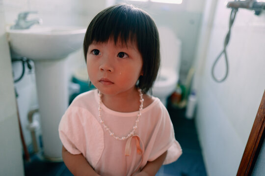 Sad little girl in the bathroom after being scolded