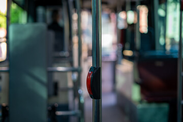 interior of a public transport bus and stop button on a blurred background