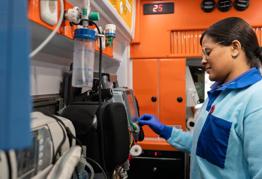 Paramedic checking equipment inside ambulance