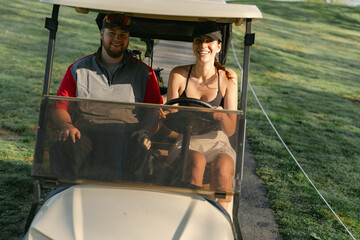  young woman driving a golf cart on the golf course 