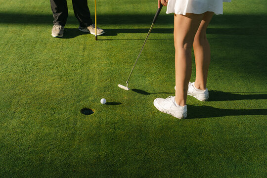 Close up of legs of young woman playing golf 