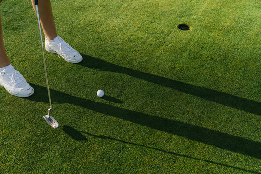 Close up of legs of young woman playing golf 
