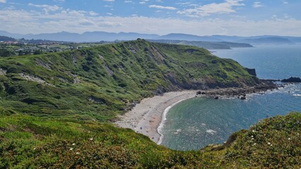 Mesmerizing Coastal Vista: A Sweeping View of the Boundless Ocean from a Lush, Green Cliffside. The Harmonious Blend of Verdant Nature and Infinite Blue Waters