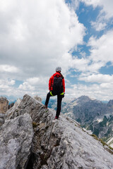 Woman Hiker Standing in Hero Pose on the Peak of the Mountain Looking into the Alpine Landscape