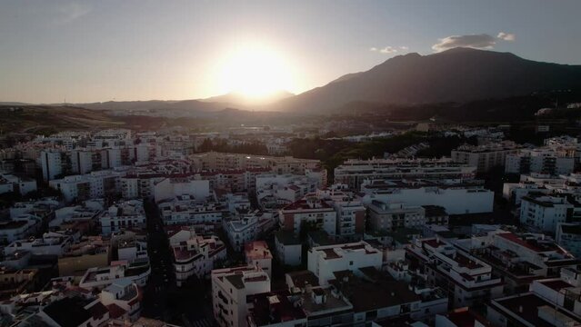 Cityscape at Sunset with Mountains in the Background and Urban Buildings in the Foreground