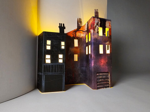 Painted house with lit windows in pages of notebook