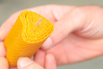 Handmade craft production of candles from natural beeswax in the shape of heart, close-up in male...