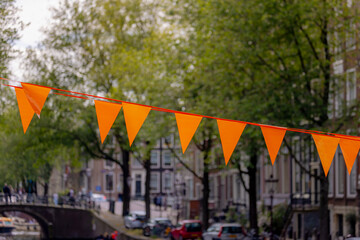 Football fever concept, Supporter hanging pennant orange flags, (Originally symbolize the Dutch) decoration above the canal with green tree as background, Netherlands national football team, Holland.