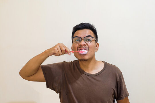 Morning routine with A Southeast asian mansmiling and cleaning his theeth for a healty life, healthycare.