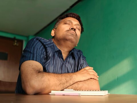 Middle aged Indian man wring inside a house