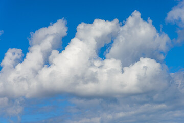 Obraz premium Unique aerial view of bodies of cumulus clear white clouds towers in bright blue sky background.