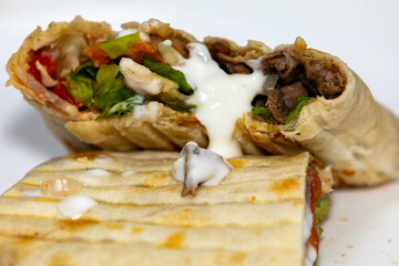 Traditional Shawarma sandwich fresh roll of, Grilled Meat and salad tortilla wrap with white sauce...
