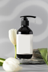 Dispenser bottle with hanging liquid drop on stone podium