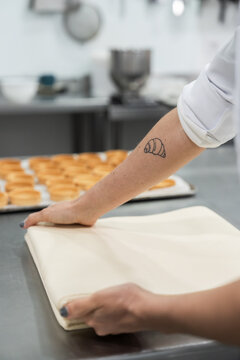 Professional pastry chef preparing baking sheet in kitchen