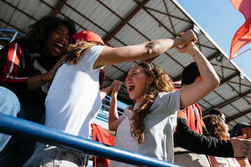 From below of excited fans celebrating victory at a game in stadium