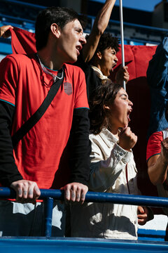 Enthusiastic fans cheering at a game in stadium