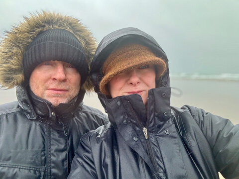 Middle aged couple selfie of a walk in bad weather.