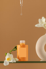 Dripping clear serum from pipette into bottle with freesias