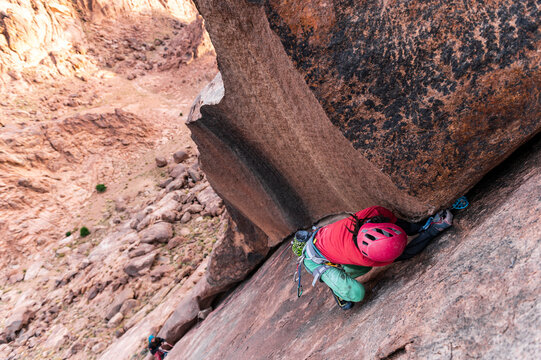 Rock climber using climbing cam on a crack