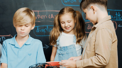 Group of caucasian student checks robotic model while taking a note.at blackboard with engineering...