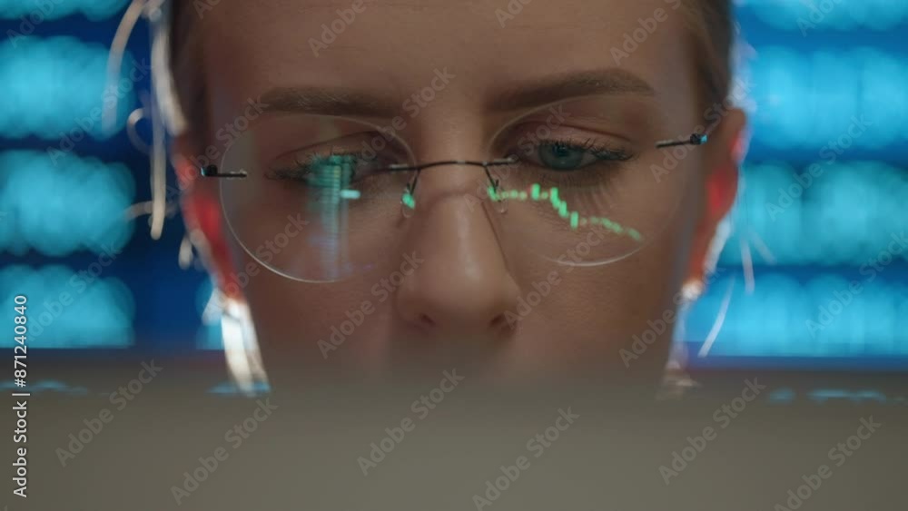 Poster trader wearing glasses is working on laptop computer. screen with stock market charts and bitcoin bt