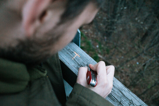 Man Engraving on Wooden Railing