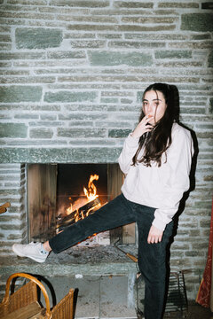 Woman by Cozy Fireplace