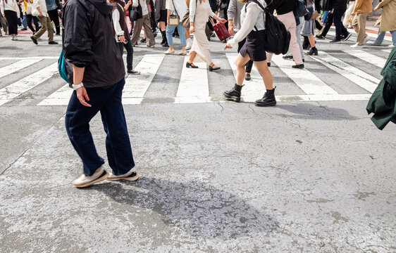 Pedestrians crossing a busy intersection during rush hour