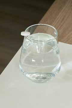 White tabletl on the edge of the glass. 