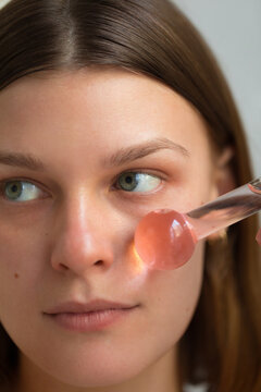 Woman using facial ice globe