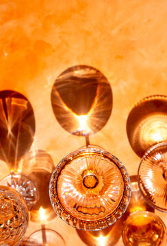 A dramatic image of glasses of wine on an orange background.