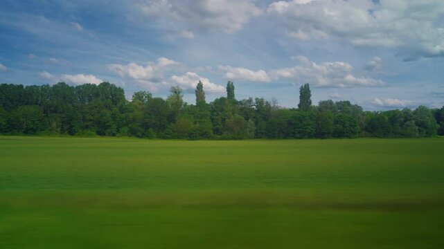 View from the window of high speed train. Beautiful trip with countryside scenery, clouds. A view of France landscape from the window of high speed train