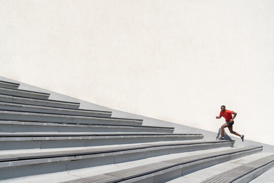 Man Running Up The Stairs At White Wall Background