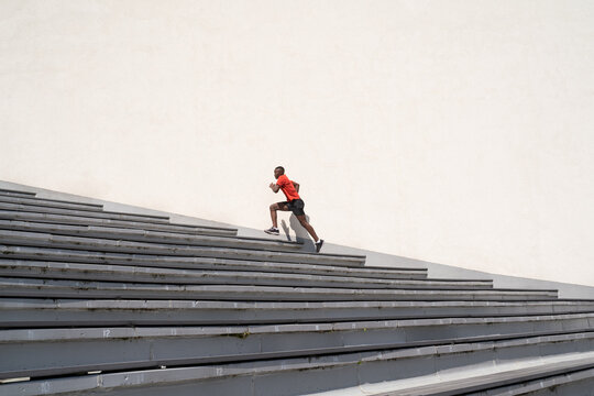 Athlete Running Up The Stairs At White Wall Background