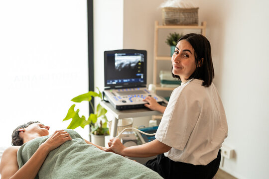 Physiotherapist using ultrasound machine.