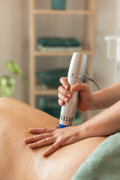 Physiotherapist doing shock wave therapy.