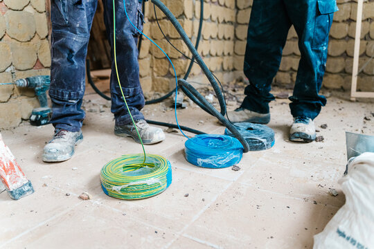 Electrical cables and wires on floor near workers
