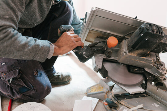 Unrecognizable carpenter sawing wood