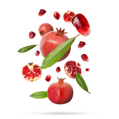 Fresh pomegranates, seeds and leaves in air on white background